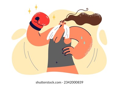 Woman in boxing glove raises hand in sign of victory over opponent and demonstrates muscles. Girl from boxing club with towel around neck, showing strength and skills gained during training