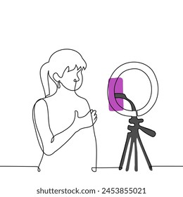 Woman broadcasts while standing in front of a phone camera mounted on a ring lamp - one line art vector. concept live stream of a female blogger. Handmade vector not AI