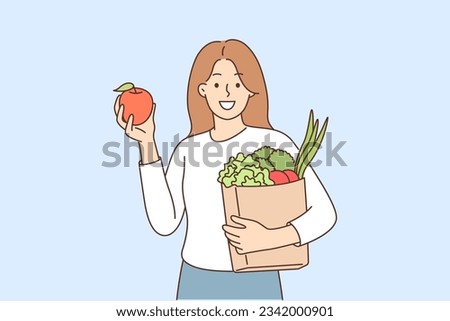 Woman buyer bought fruits and vegetables in grocery supermarket and holds paper bag recommending to refuse plastic packaging. Girl buyer of organic food store smiles and looks at screen
