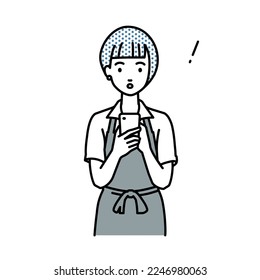 a woman in cafe apron found and noted something standing, looking in and using smart phone in her hands