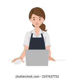 a woman in cafe apron using laptop computer at her desk