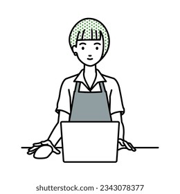 a woman in cafe apron using laptop computer at her desk