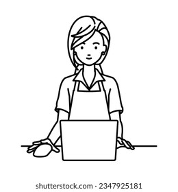 a woman in cafe apron using laptop computer at her desk
