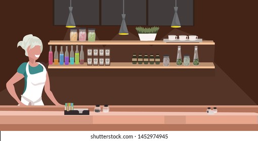 woman cafe waitress barista in apron standing at counter desk modern coffee shop interior flat portrait horizontal