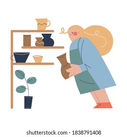 Woman carrying handmade jug from clay to shelf in pottery studio