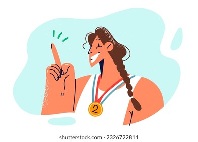 Woman champion with medal for second place points finger up and smiles, rejoicing at triumph in sports tournament. Sportswoman with medal for achievements in championship recommends playing sports