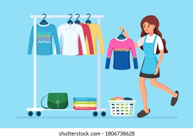Woman chooses, trying on dress. Girl near wardrobe. Metal rack with clothes, bags on hangers in boutique. Store stand with fashionable outfit. Interior of dressing room. Vector cartoon design