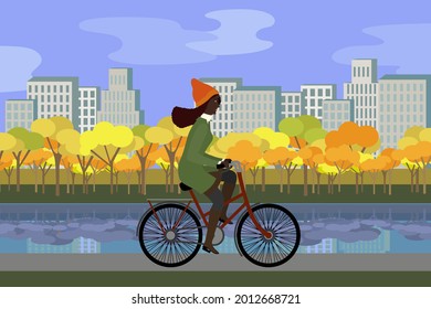 Woman in coat in the park riding bicycles in autumn