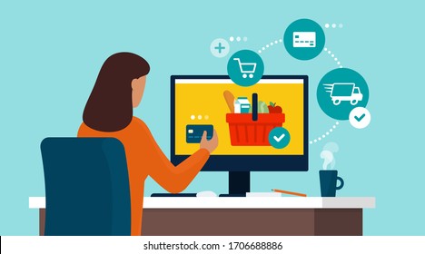 Woman connecting with her computer and doing grocery shopping online, she is ordering and purchasing products using a credit card