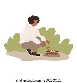 Woman cooking on campfire. Active toursim, camping, staying outdoors.