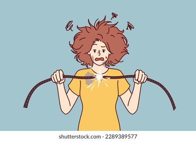 Woman with damaged electrical wire suffers from electric shock and power failure. Funny girl with disheveled hair was shocked after feeling shock from electricity and trying to fix wiring