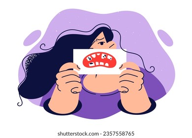 Woman demonstrates bad teeth drawn on paper, drawing attention to consequences of using poor-quality toothbrush and toothpaste. Girl shows rotten teeth, calling to contact dentist or stomatologist