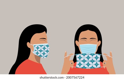 A woman demonstrates how to wear double mask properly as self-protection during Covid-19 pandemic.