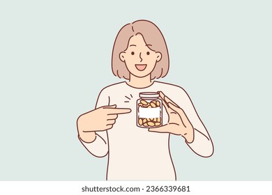 Woman demonstrates jar omega-3 vitamins or fish oil designed to improve health and immunity. Girl holds package with golden capsules, recommending use of vitamins d3 for preventative disease control