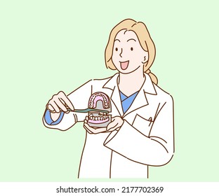 Woman dentist showing on a jaw model how to clean the teeth with toothbrush. Hand drawn in thin line style, vector illustrations.