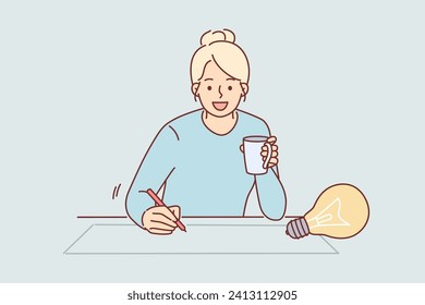 Woman designer draws idea for architectural project on paper, sitting at table with cup of coffee in hands. Inspired girl designer creates action plan or sketch of advertising poster.