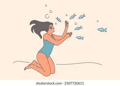 Woman diver swims underwater among fish, holding breath without using scuba gear and mask. Girl diver relaxes at southern resort with opportunity to swim and snorkel in warm ocean with sea animals