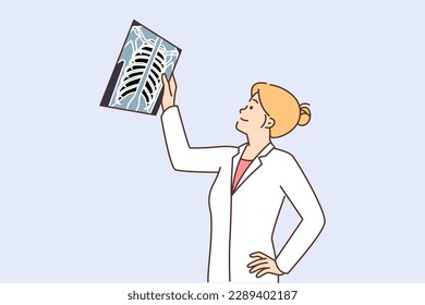 Woman doctor examines x-ray of person chest in search of symptoms of dangerous diseases. Girl doctor in white coat examines x-ray of patient received fracture or fracture of rib bone 
