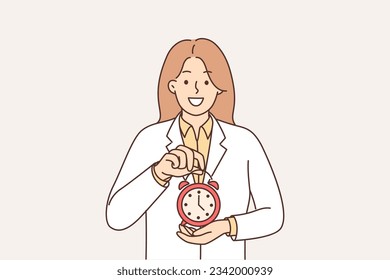 Una doctora sostiene un reloj de alarma recomendando atenerse al horario para tomar medicamentos o visitar una clínica. La terapeuta con abrigo blanco recuerda que es hora de acudir al médico.