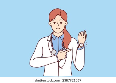 Woman doctor points to wristwatch reminding of medication schedule or time to visit clinic. Girl doctor in white coat with stethoscope around neck smiles reporting hospital opening hours