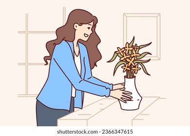 Woman does home staging and puts vase of flowers on table to prepare apartment for sale or rent. Girl designer provides home staging services for property owners wishing to make good deal