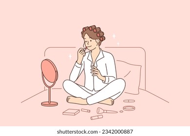 Woman does makeup sitting in bed early in morning and paints lips while looking in mirror before going to important meeting. Girl in pajamas making makeup applying cosmetics to hide skin imperfections svg