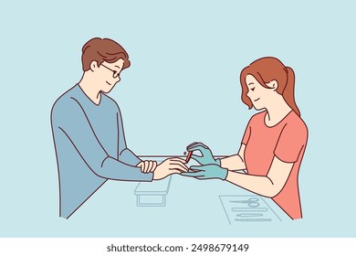 Woman does manicure for man who cares about nail hygiene and well-groomed hands, or absence of uncut cuticles. Specialist processes fingernails with file during manicure session for guy