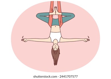 Woman doing aerial yoga hangs upside down in hammock and keeps balance with arms at sides. Girl during workout in yoga studio meditates enjoying practices that cause harmony and get rid of nerves