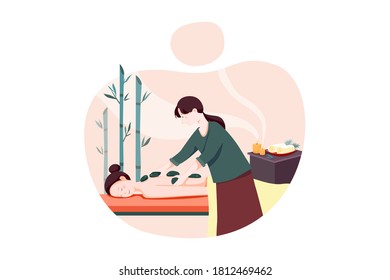 Woman doing massage to a woman with rocks