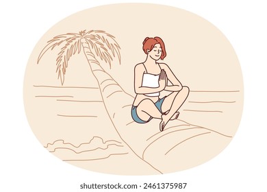 Woman doing yoga sitting on palm tree in lotus position enjoying summer travel and meditating on beach. Girl relaxing on beach with sea is fond of yoga and sunbathing during trip to island in ocean