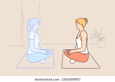 Woman doing yoga with virtual trainer sitting on fitness mat in lotus position and looking at hologram of instructor. Girl who is fond of yoga trains to meditate using innovative technologies