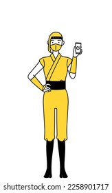 A woman dressed up as a ninja using a smartphone at work.