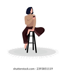 Woman drinking hot tea while sitting on stool against white back