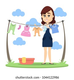 Woman drying baby clothes outdoors with hanger.