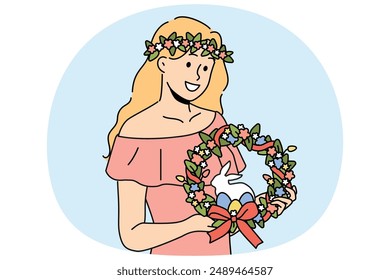 Woman with easter wreath on head smiles and holds colored eggs and miniature rabbit. Girl dressed in pink dress with easter accessories inviting to celebrate religious christian holiday