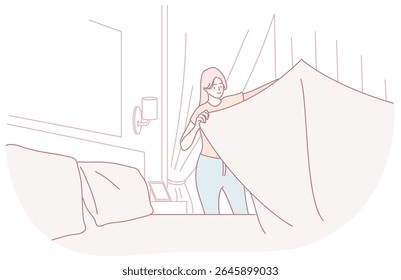 A woman elegantly and gracefully drapes a soft blanket over a couch in a tranquil and serene living space