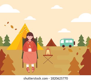 Woman enjoying autumn camping. The woman is sitting in a chair, drinking tea and relaxing.