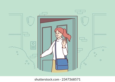 Woman enters house opening door and turning around to wave goodbye and wish good luck. Young beautiful girl stands on porch of dwelling near entrance and says goodbye after date or walk