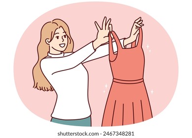 Woman examines beautiful evening dress choosing outfit for going to ball or festive party. Girl shopping in clothing store holds elegant dress from latest collection from famous fashion designer