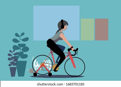 A woman exercise at home by cycling a bike on roller trainer.