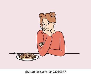 Woman experiences lack of appetite and sadly looks at plate of spaghetti due to psychological problems and bulimia. Girl suffers from poor appetite causing digestive disorders and bulimia.