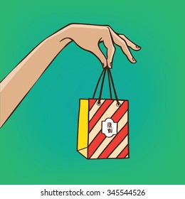Woman extends her hand with the shopping bag - sale or gift concept