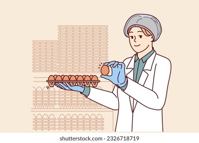 Woman factory worker holds chicken eggs while checking finished product for compliance with quality standards. Young girl factory technologist in white coat works in food industry.