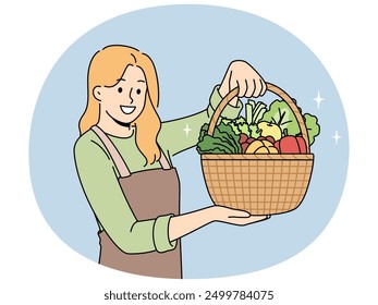 Woman farmer with basket full of vegetables recommends eating natural organic food grown without pesticides. Beautiful girl farmer in apron works as seller in vegetable shop with useful products