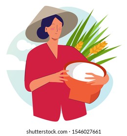 Woman farmer holding basket wearing cap in rice padi field harvesting. Traditional farming organic nature