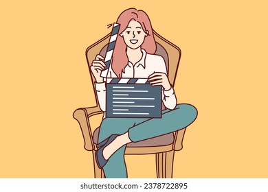 Woman film producer holds clapperboard and smiles sitting in chair to invite actors to participate in casting. Girl director demonstrates clapperboard after completing shooting of next take svg