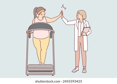 Woman fitness doctor monitors progress of oversized female exercising on treadmill in gym. Fitness doctor in white coat gives high five to fat girl wants to lose weight for slim body