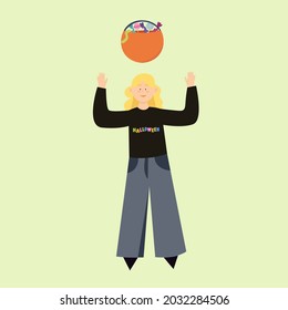 A woman in flared jeans wearing a sweatshirt with Halloween written on it. Basket of sweets for the fall holiday. 