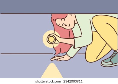Woman with flashlight looks under bed to find old things or check for monsters before going to bed. Girl with flashlight is afraid and looks intrigued into darkness after hearing rustle