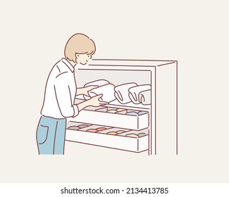 Woman folding clothes, organizing stuff in baskets and boxes. Concept of clothes storage, minimalism lifestyle. Hand drawn style vector design illustrations.